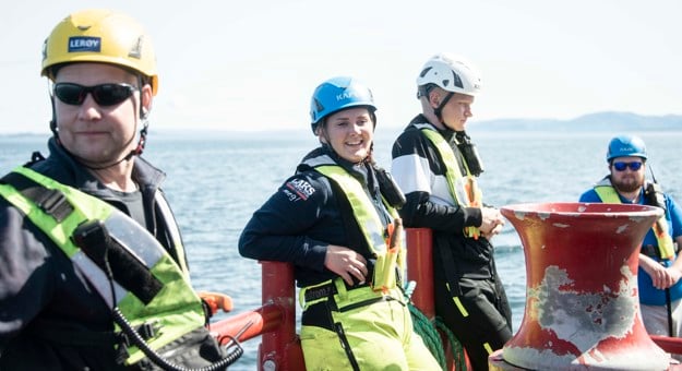 Employees with gear outside working at the fish cages