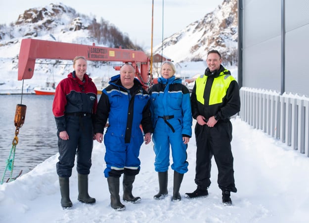 Natur i bakgrunnen med hvit snø. I fokus i midten står en kvinne, en eldre mann, en kvinne og en yngre mann. Familien Skog. 