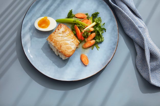 Cod with egg and vegetables on a plate