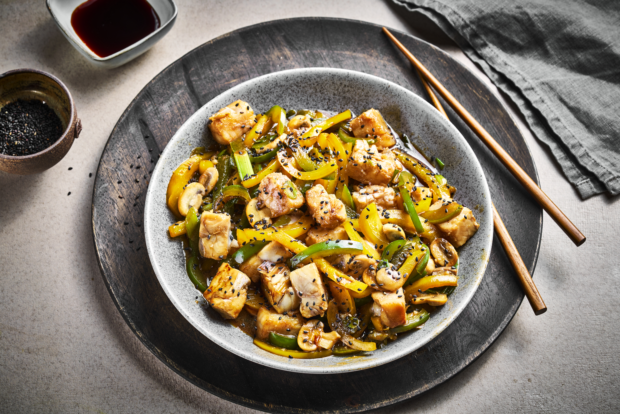 Asiatisk wok med torsk og sei, i serveringsskål. Rustikk