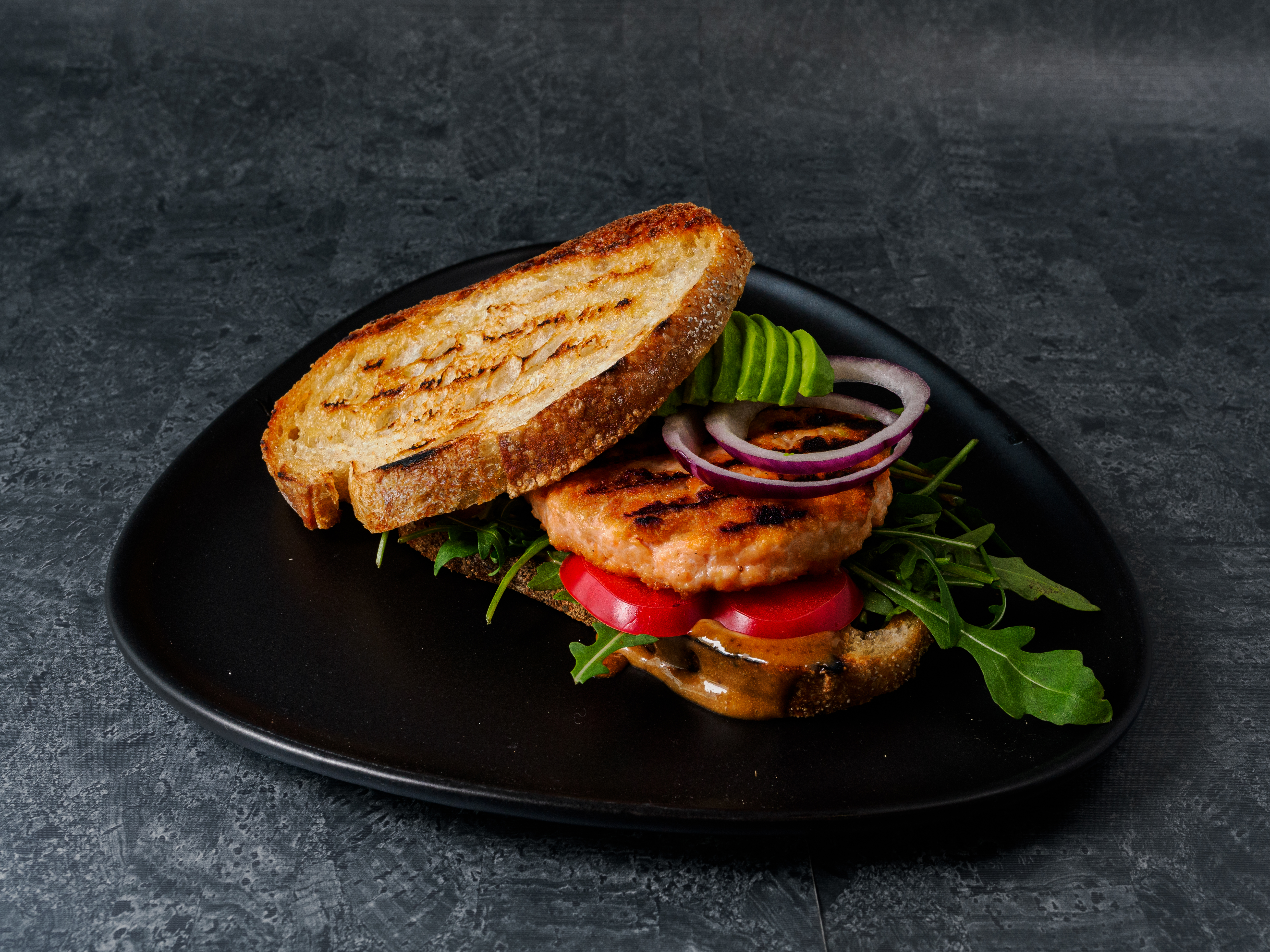 En tallerken med lakseburger med friske grønnsaker